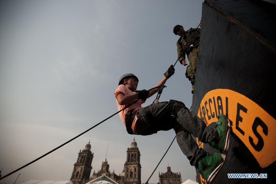 A boy participates in an activity during the Mexican Army's Exhibition "Armed Forces, Passion to Serve Mexico" held in the Zocalo of Mexico City, capital of Mexico, on Feb. 15, 2013. (Xinhua/Pedro Mera) 