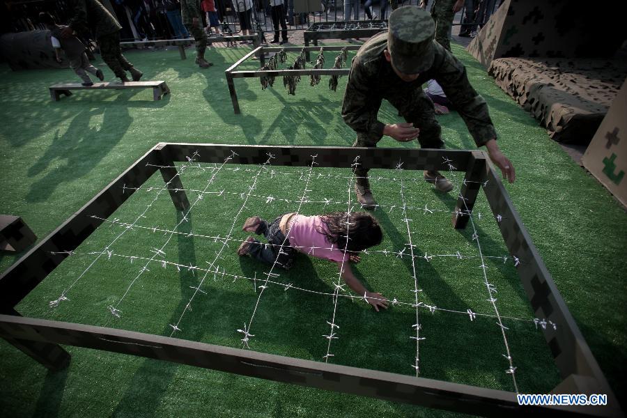 A girl participates in an activity during the Mexican Army's Exhibition "Armed Forces, Passion to Serve Mexico" held in the Zocalo of Mexico City, capital of Mexico, on Feb. 15, 2013. (Xinhua/Pedro Mera) 