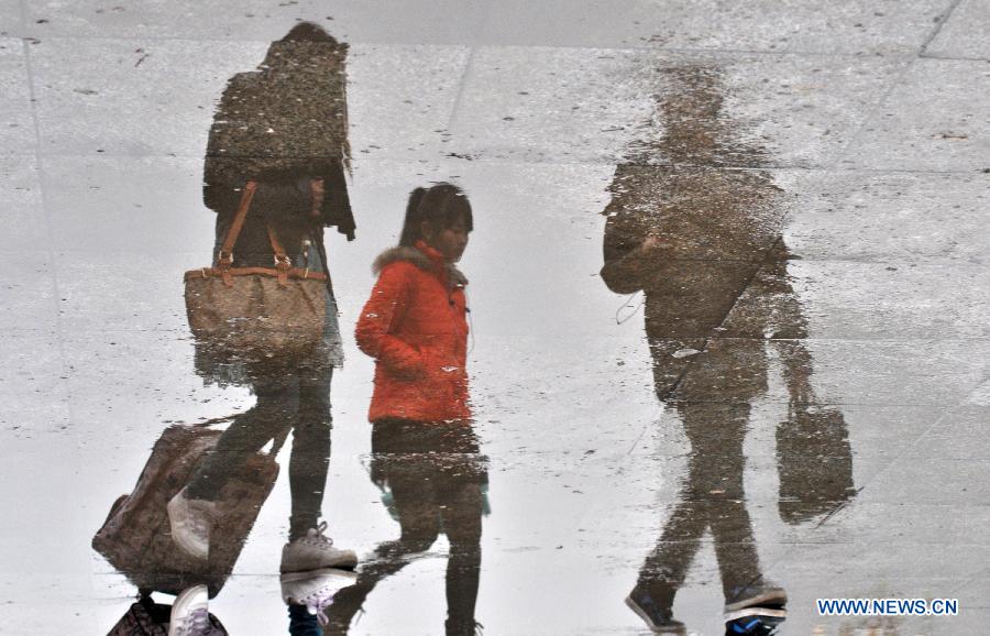 Passengers are seen reflected on the ground as they walk in the city railway station in Jiujiang, east China's Jiangxi Province, Feb. 17, 2013. China saw a travel rush after the week-long Spring Festival holiday as millions of workers move to big cities for better working opportunities. (Xinhua/Hu Guolin) 