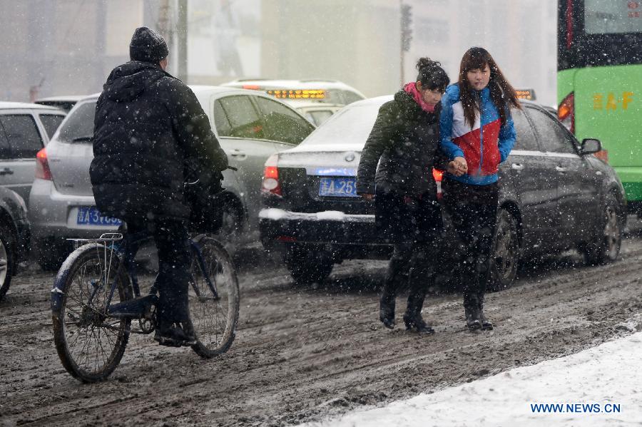 People walk in snow in Changchun, capital of northeast China's Jilin Province, Feb. 17, 2013. Snow hit the province on Sunday. (Xinhua/Lin Hong) 