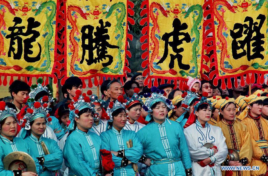 File photo taken on May 13, 1996 shows folk artists watching a Shehuo performance in Zhengzhou, capital of central China's Henan Province. (Xinhua/Wang Song)