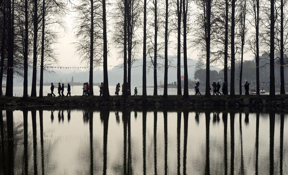 Visitors walk through a plum blossom park in Wuhan, Hubei province, Feb. 12, 2012. Wuhan's weather turned warm during the Spring Festival holiday and many citizens went outdoors to enjoy the blooming flowers. (Xinhua/Cheng Min)