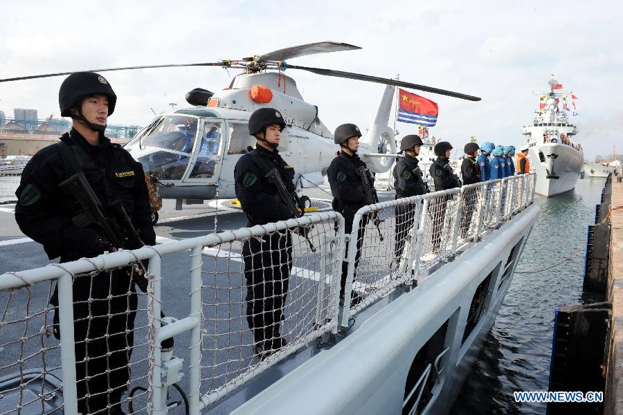 Chinese Navy special force members stand on the deck of a missile frigate "Mianyang" , waiting to depart for the Gulf of Aden and the sea off Somalia on escort missions, at a port in Qingdao City, east China's Shandong Province, Feb. 16, 2013, The flotilla, as the 14th batch of its kind to engage in escort missions, consists of a missile destroyer and a frigate as well as a supply ship which are all from the North Sea Fleet of the People's Liberation Army (PLA) Navy. (Xinhua/Li Ziheng) 
