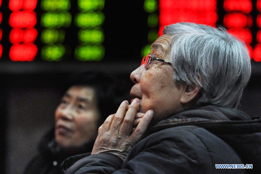 An investor views share price information at a securities trading center in east China's Shanghai, Feb. 18, 2013. Chinese stocks closed lower on Monday. The benchmark Shanghai Composite Index closed at 2,421.56 points, down 0.45 percent, or 10.84 points. The Shenzhen Component Index dropped 1.93 percent, or 193.19 points, to end at 9,795.91. (Xinhua/Zhu Lan) 