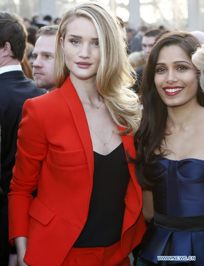 Rosie Huntington-Whiteley (L) and Freida Pinto attend the Burberry Prorsum Autumn/Winter 2013 Womenswear Show at Kensington Gardens during London Fashion Week in London, Britain, on Feb. 18, 2013.(Xinhua/Wang Lili) 