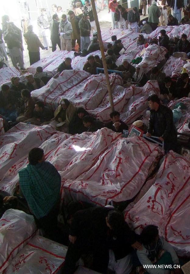 Shiite Muslims sit next to bodies and await the burial of their relatives and friends who were killed in a deadly bombing, during a protest in southwest Pakistan's Quetta, on Feb. 18, 2013. Up to 4,000 Pakistani Shiites protested in Quetta for a second day on Monday, after a bomb in the city killed 84 Shiite Muslims, blocking a main road with dozens of coffins of victims killed in explosions. (Xinhua/Mohammad)