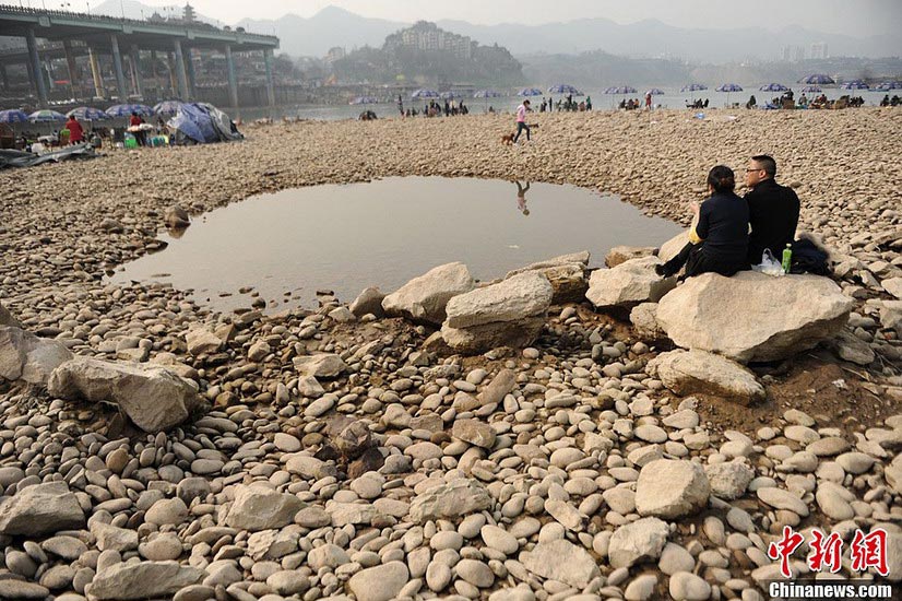 People are seen having fun on the exposed bed of Jialing River in Southwest China's Chongqing municipality on Feb 18, 2013. (Photo/Xinhua)