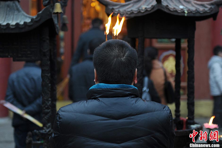 A man burns incenses at the Guangren Lama Temple in Xi'an, Shaanxi Province, February 17, 2013. Many people went to the temple to pray for good fortune on Sunday. (CNS/Zhang Yuan)