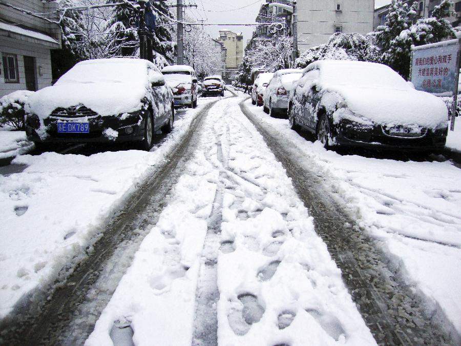 Snow covers a road and cars after snowfall in a community in Changshu, east China's Jiangsu Province, Feb. 19, 2013. A snowstorm hit Jiangsu province on Feb. 19 morning and local meteorological bureau has issued a blue alert for the snowfall. (Xinhua)