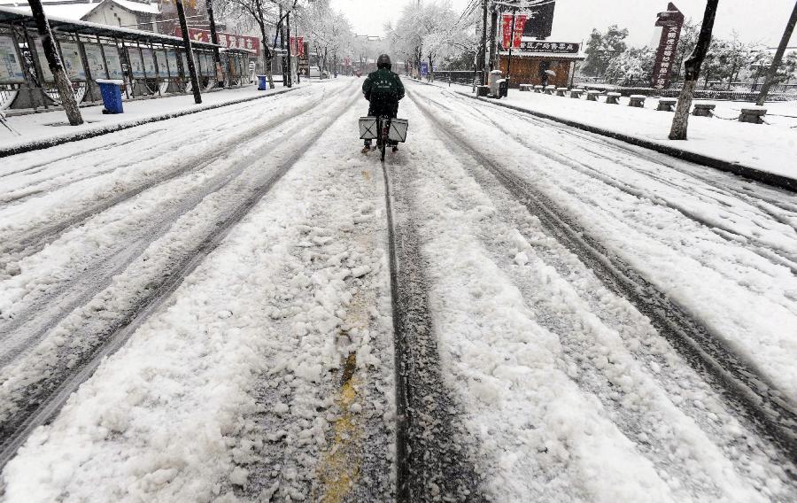  citizen rides a bicycle on a snowy road in Jiangsu, east China's Jiangsu Province, Feb. 19, 2013. A snowstorm hit Jiangsu province on Feb. 19 morning and local meteorological bureau has issued a blue alert for the snowfall. (Xinhua/Hang Xingwei) 