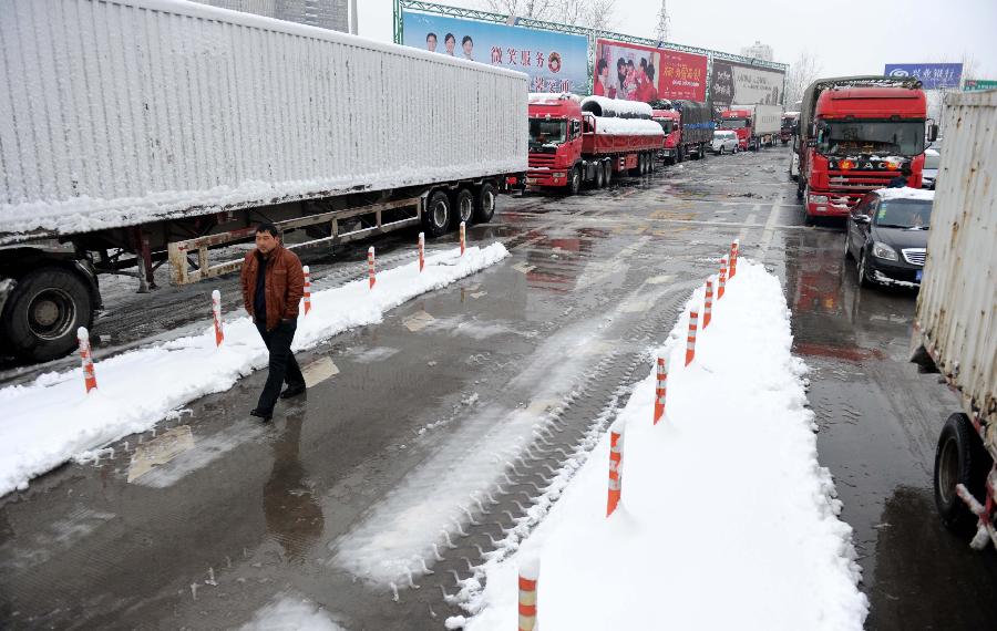 Vehicles wait at the entrance of an intercity express way which has been closed due to heavy snowfall in Hefei, capital of east China's Anhui Province, Feb. 19, 2013. Snowstorm hit multiple places in Anhui Tuesday morning, disturbing the local traffic. (Xinhua/Liu Junxi) 