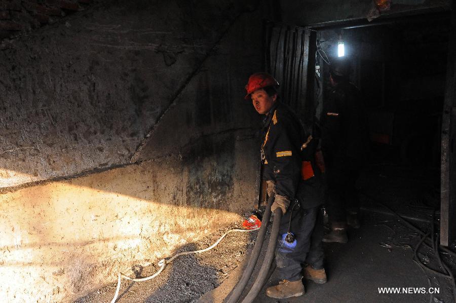 A rescuer lays the suction pipe at a coal mine in Madixiang Community of Yangquan, north China's Shanxi Province, Feb. 19, 2013. Six people have been trapped underground since a coal mine in Yangquan City was flooded at about 4 a.m. Tuesday, when 12 people were conducting illegal mining operations, the local government said.(Xinhua/Fan Minda) 