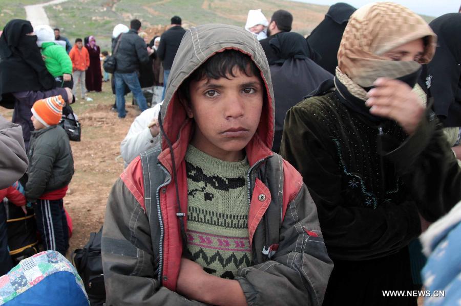 Syrian refugees fleeing violence take a rest near Mafraq as they cross the border from Syria into Jordan, Feb. 18, 2013. According to the Jordanian Armed Forces sources, around 89,000 Syrian refugees fleeing from the violence in their country have crossed the Jordanian border since the beginning of 2013. (Xinhua/Mohammad Abu Ghosh)  