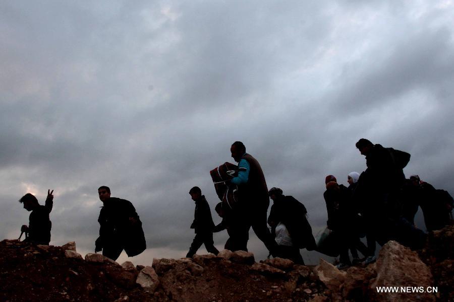 Syrian refugees walk near Mafraq as they cross the border from Syria into Jordan, Feb. 18, 2013. According to the Jordanian Armed Forces sources, around 89,000 Syrian refugees fleeing from the violence in their country have crossed the Jordanian border since the beginning of 2013. (Xinhua/Mohammad Abu Ghosh)  