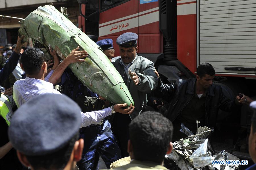 Policemen collect wreckage of the crashed plane in Sanaa, Yemen, Feb. 19, 2013. A Yemeni military helicopter on a training mission crashed in a crowded neighborhood in central capital Sanaa on Tuesday, leaving at least nine people dead and 23 others injured, local officials and witnesses said. (Xinhua/Mohammed Mohammed)