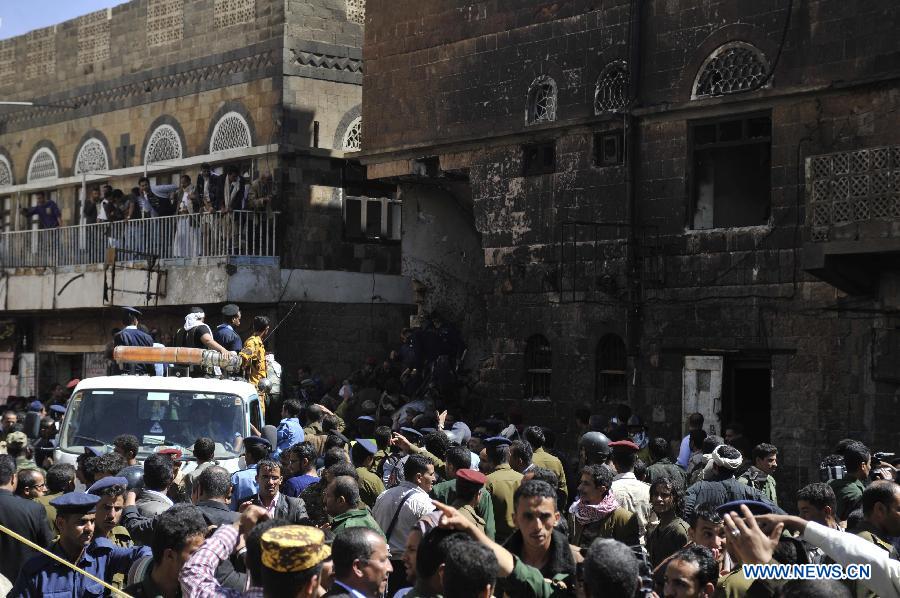 People gather at the crash site in Sanaa, Yemen, Feb. 19, 2013. A Yemeni military helicopter on a training mission crashed in a crowded neighborhood in central capital Sanaa on Tuesday, leaving at least nine people dead and 23 others injured, local officials and witnesses said. (Xinhua/Mohammed Mohammed)  