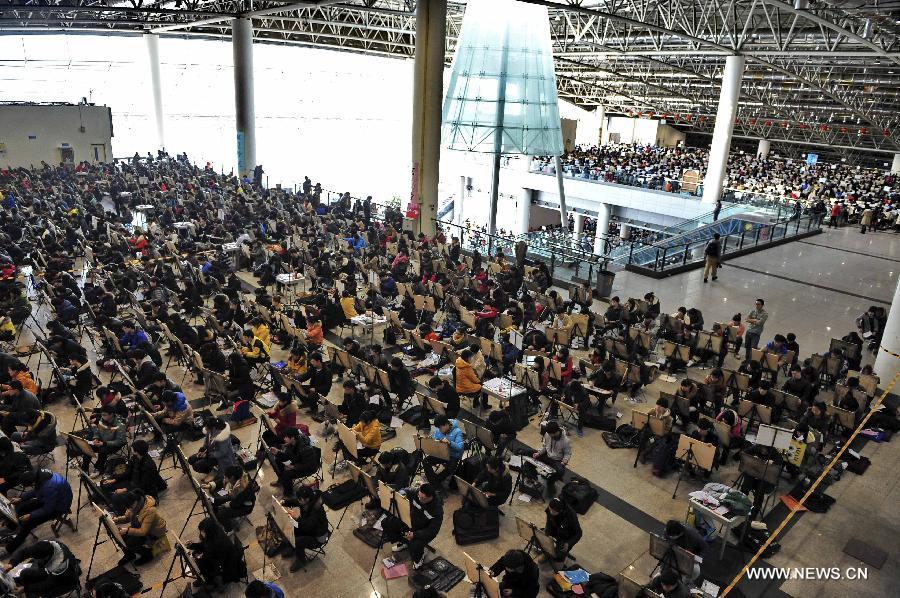 Candidates of Shandong University of Art and Desgin sit for painting examination at Jinan Shungeng International Exhibition Center in Jinan, capital of east China's Shandong Province, Feb. 20, 2013. More than 100,000 students applied for the entrance examination of China's art colleges in Shandong Province this year, up about 10 percent as compared to the number of last year. (Xinhua) 