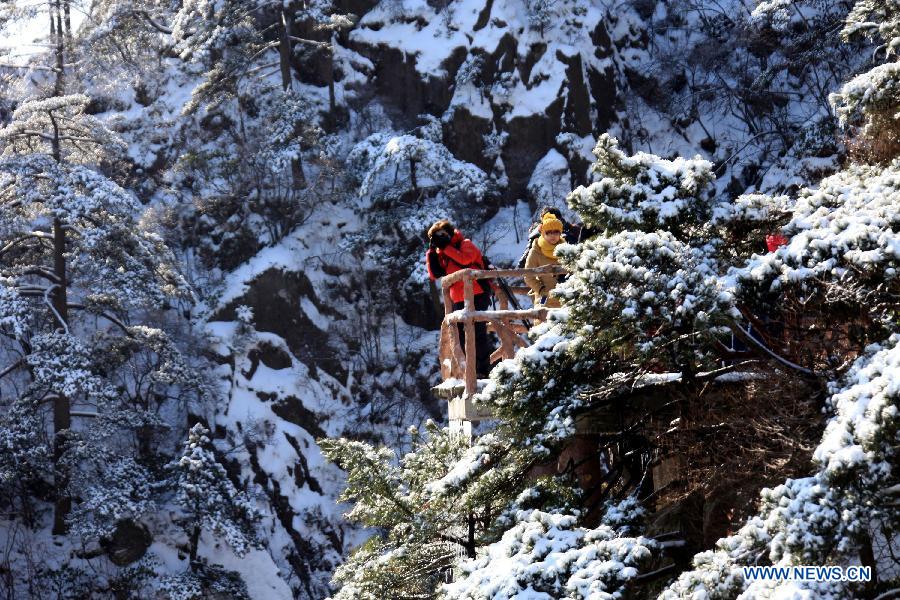 A visitor takes photos of the snow scene at the Huangshan Mountain scenic area in east China's Anhui Province, Feb. 20, 2013. (Xinhua/Shi Guangde) 