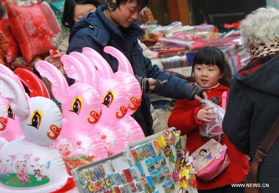 A girl buys a lantern at a market in Shanghai, east China, Feb. 20, 2013. An annual lantern sales boom appeared with the approaching of the Lantern Festival which falls on Feb. 24 this year. (Xinhua/Pei Xin) 