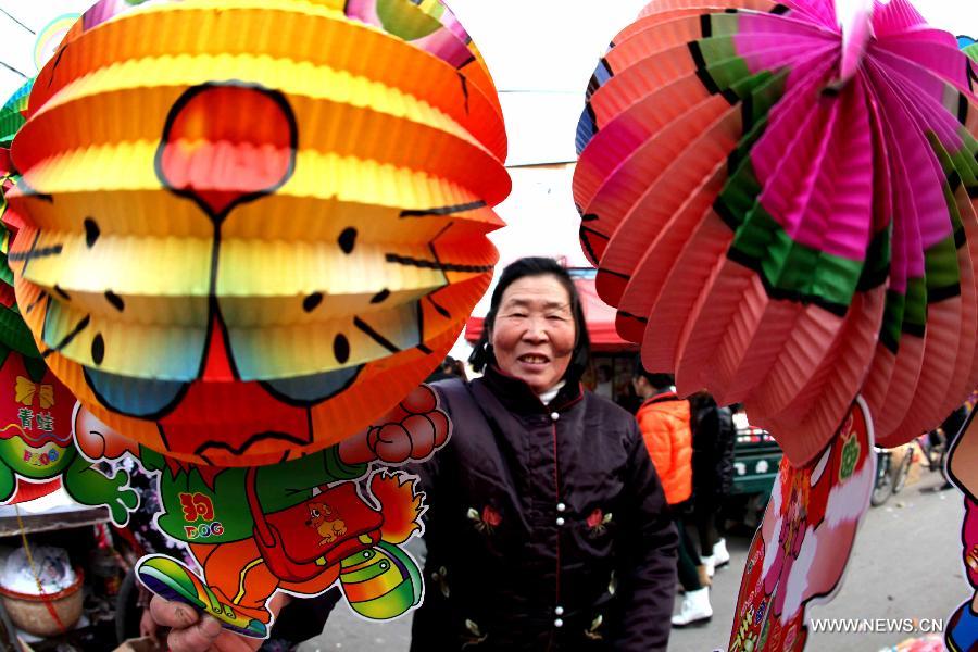 A woman looks at lanterns made with environment-friendly paper at a market in Bozhou, east China's Anhui Province, Feb. 20, 2013. An annual lantern sales boom appeared with the approaching of the Lantern Festival which falls on Feb. 24 this year. (Xinhua/Liu Qinli) 