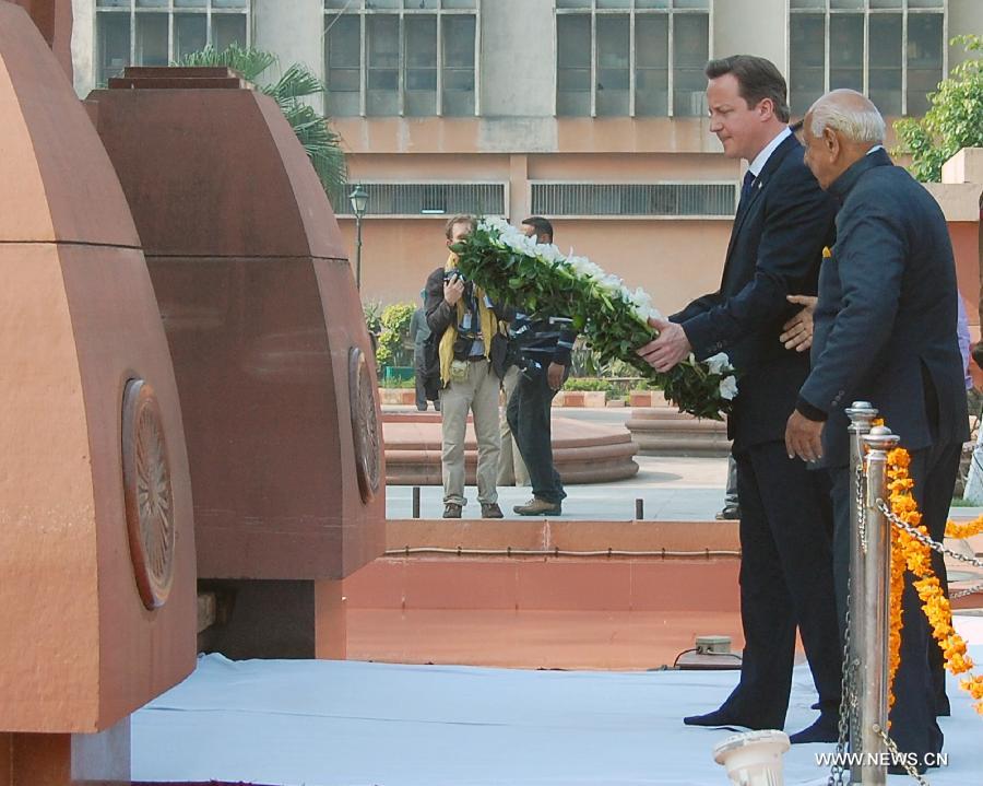British Prime Minister David Cameron (L) offers a floral wreath at the memorial of the 1919 massacre during his visit in Amritsar, India, Feb. 20, 2013. British Prime Minister David Cameron Wednesday paid homage to the victims of the 1919 killing of civilians by British troops in northwest Indian city of Amritsar. (Xinhua/Stringer) 