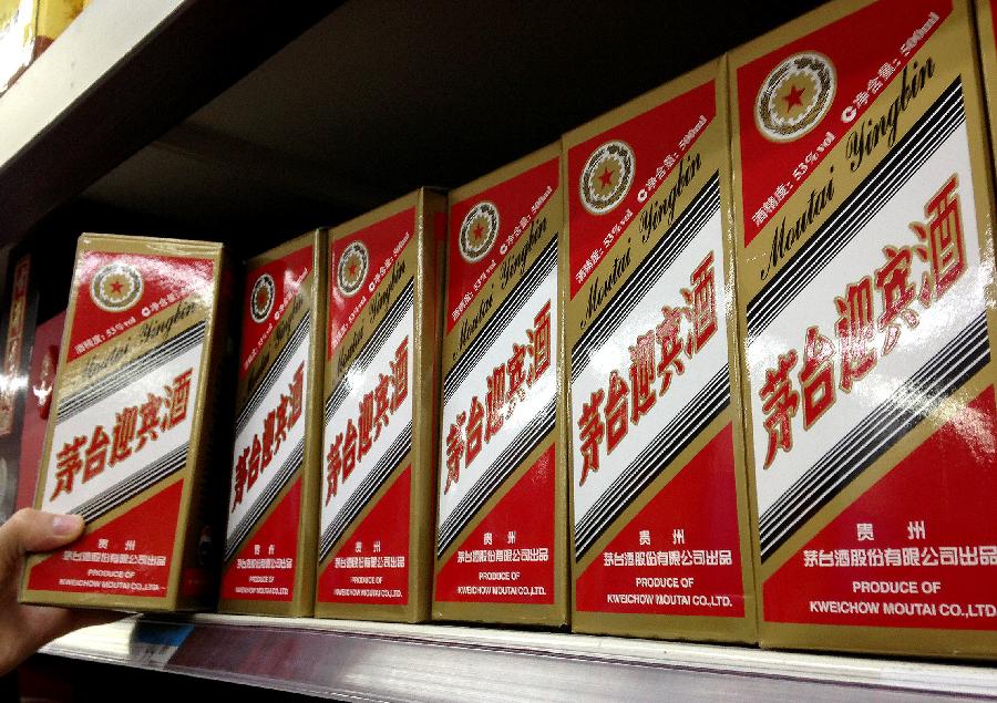 A man takes a bottle of Kweichow Moutai Liquor at a supermarket in Beijing, capital of China, Feb. 19, 2013. Two Chinese liquor makers, Kweichow Moutai Co. Ltd and Wuliangye Yibin Co. Ltd, have been fined 449 million yuan, equivalent to 1 percent of all sales of the two companies throughout 2012, for their involvement in price monopoly activity. (Xinhua/Li Xin)