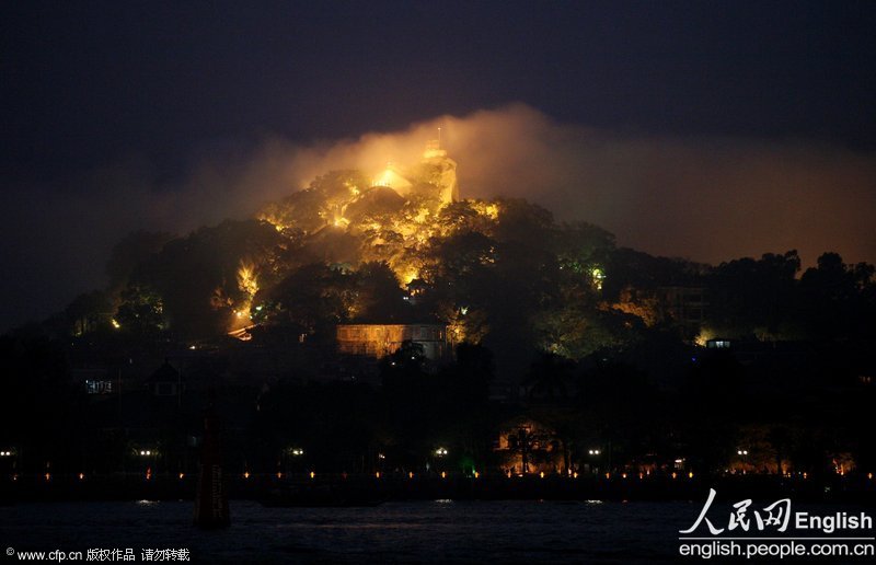 Sunlight Rock, renowned scenic spot in Xiamen, southeast China's Fujian province, presents a fantastic impression amid advection fog and colorful light, Feb. 18, 2013. Advection fog appears mostly in winter when damp air crosses a cooler surface, according to local meteorological department. (Photo/CFP)