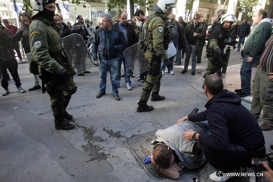 Demonstrators clash with riot police in central Athens, Greece, Feb. 20, 2013. A 24-hour general strike was organized by the two largest confederations of private sector workers (G.S.E.E.) and public sector employees (A.D.E.D.Y.) against the harsh and ineffective austerity measures, the sharp rise of unemployment and the government's plans to limit the labor unions' right to strike. (Xinhua/Marios Lolos) 