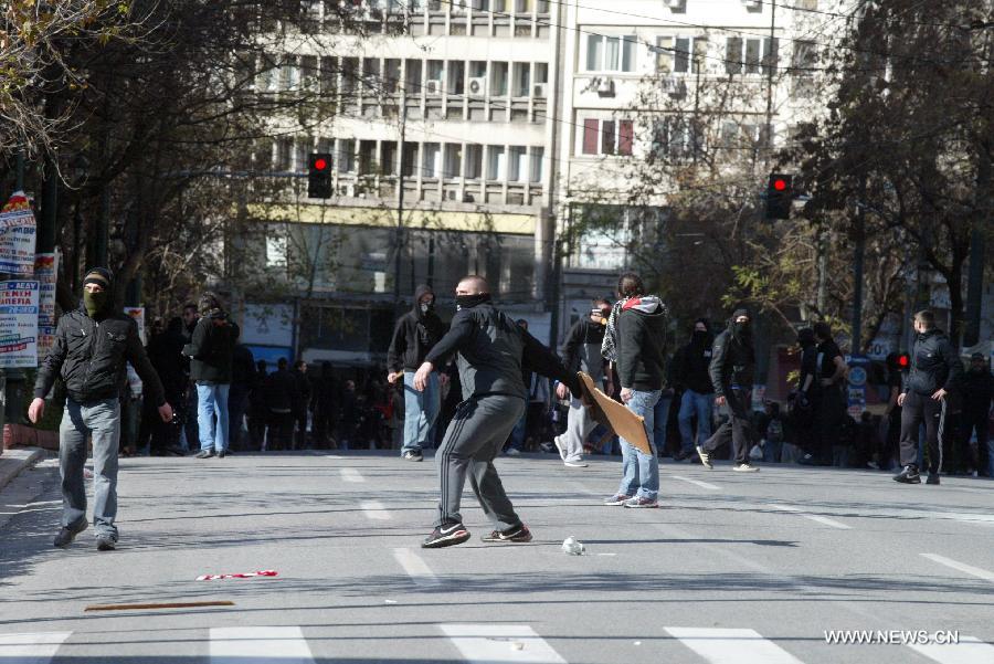 Demonstrators clash with riot police in central Athens, Greece, Feb. 20, 2013. A 24-hour general strike was organized by the two largest confederations of private sector workers (G.S.E.E.) and public sector employees (A.D.E.D.Y.) against the harsh and ineffective austerity measures, the sharp rise of unemployment and the government's plans to limit the labor unions' right to strike. (Xinhua/Marios Lolos) 