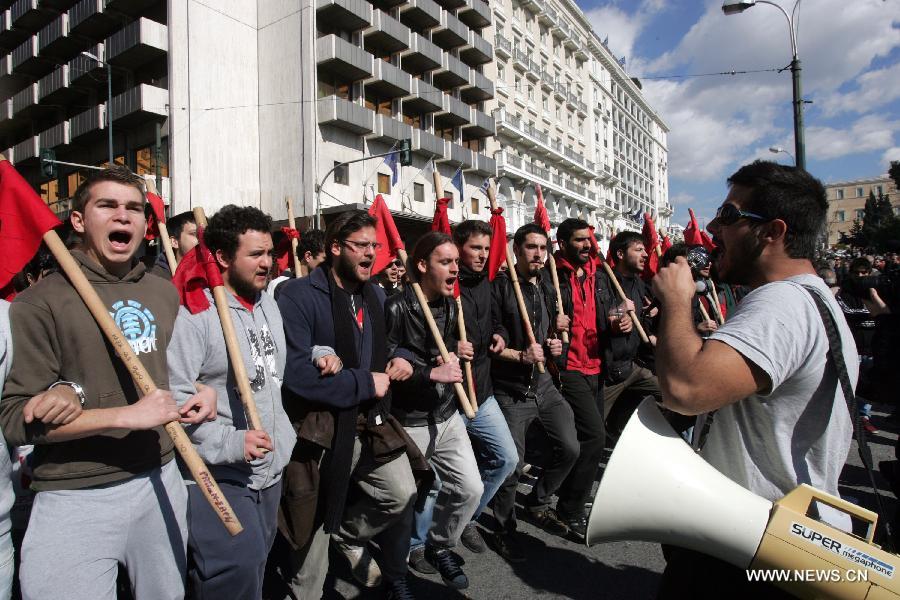 Demonstrators shout slogans and hold banners in front of the House of Parliament in central Athens, Greece, Feb. 20, 2013. A 24-hour general strike was organized by the two largest confederations of private sector workers (G.S.E.E.) and public sector employees (A.D.E.D.Y.) against the harsh and ineffective austerity measures, the sharp rise of unemployment and the government's plans to limit the labor unions' right to strike. (Xinhua/Marios Lolos) 