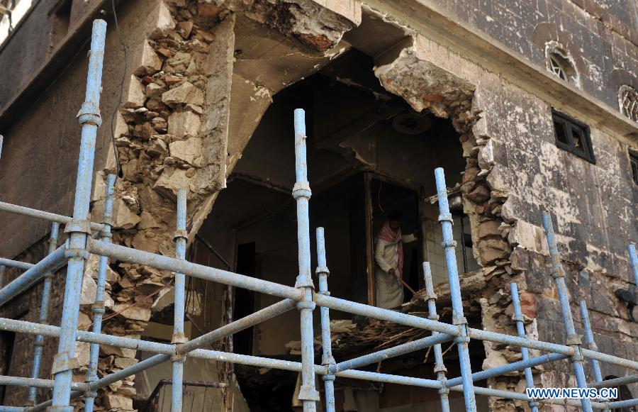 Yemeni workers try to prevent the house from collapse in order to search for victims and take out wreckages of the crashed plane, in Sanaa, Yemen, on Feb. 20, 2013. The Yemeni supreme security commission said the death toll from Tuesday's fighter jet crash has hit 10, including two children, in a residential area of capital Sanaa, according to a statement carried by state-run Saba news agency. (Xinhua/Mohammed Mohammed) 