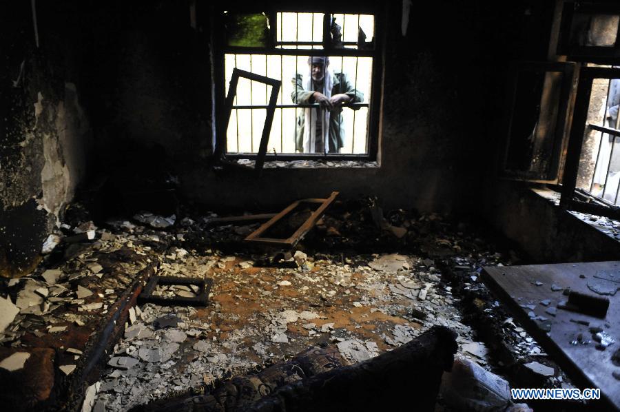 A man inspects his house that was damaged by a crashed plane, in Sanaa, Yemen, on Feb. 20, 2013. The Yemeni supreme security commission said the death toll from Tuesday's fighter jet crash has hit 10, including two children, in a residential area of capital Sanaa, according to a statement carried by state-run Saba news agency. (Xinhua/Mohammed Mohammed) 