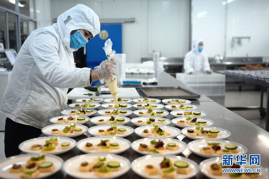 A worker prepares airline food inside China Southern Airlines' Changchun in-flight food company, on Jan. 31, 2013. The company is capable of providing airline meals for more than 7,000 passengers every day during the Spring Festival travel peak. The whole procedure, from purchasing the raw materials to getting the prepared food onto the plane, takes at least six hours. [Xinhua]