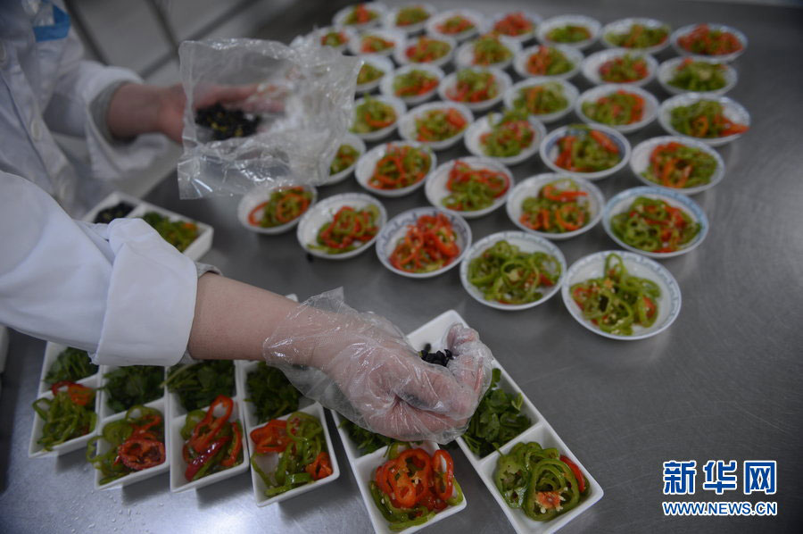 A worker prepares airline food inside China Southern Airlines' Changchun in-flight food company, on Jan. 31, 2013. The company is capable of providing airline meals for more than 7,000 passengers every day during the Spring Festival travel peak. The whole procedure, from purchasing the raw materials to getting the prepared food onto the plane, takes at least six hours. [Xinhua] 