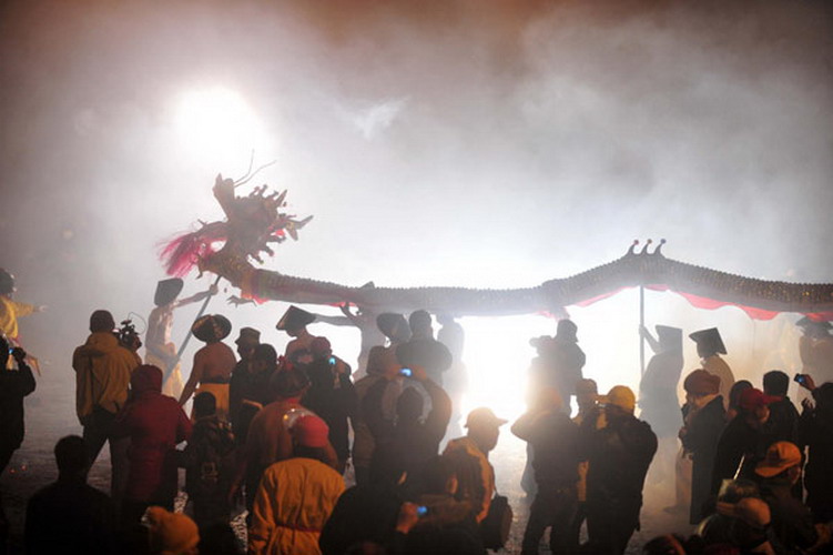 People perform a dragon dance among the fireworks in downtown Bingyang county in South China's Guangxi Zhuang autonomous region on Feb 20, 2013. (Photo/Xinhua)