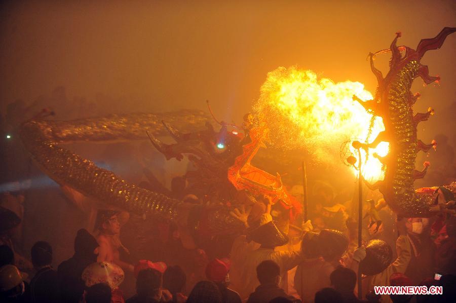 People perform dragon dance in firecrackers in Binyang County of south China's Guangxi Zhuang Autonomous Region, Feb. 20, 2013. The Binyang-style dragon dance is a derivative of traditional dragon dance in which performers hold dragon on poles and walk through floods of firecrackers. The dance, dating back to over 1,000 years ago, was listed as a state intangible cultural heritage in 2008. (Xinhua/Huang Xiaobang) 