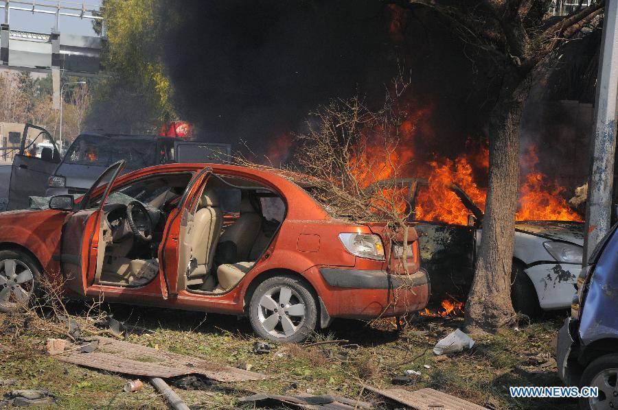 A handout picture released by the official Syrian Arab News Agency (SANA) shows burning cars after a blast in Damascus, Syria, Feb. 21, 2013. A big blast rocked a busy intersection in the capital Damascus Thursday close to the ruling al-Baath party headquarters, leaving unspecified number of casualties, witnesses and reports said. (Xinhua/SANA) 