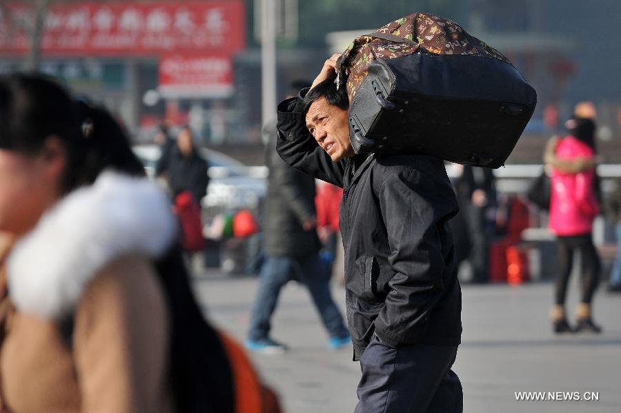 A man carries his bag on the square of the train station in Taiyuan, capital of north China's Shanxi Province, Feb. 21, 2013. Many people started their trips back to their working places after the Spring Festival holiday in recent days. (Xinhua/Zhan Yan)