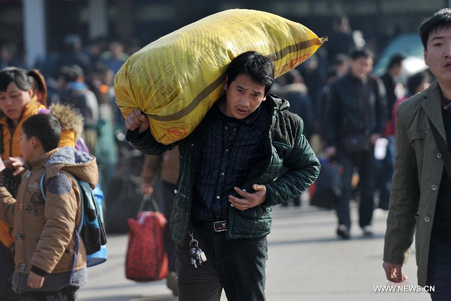 A man carries his bag on the square of the train station in Taiyuan, capital of north China's Shanxi Province, Feb. 21, 2013. Many people started their trips back to their working places after the Spring Festival holiday in recent days. (Xinhua/Zhan Yan) 