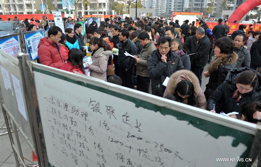 Job applicants browse employment information on a job fair in Hefei, capital of east China's Anhui Province, Feb. 21, 2013. A job fair was held at the Binhu District to help the people who has difficulties finding jobs. A total of 150 companies participated the job fair with over ten thousands of employment positions. (Xinhua/Guo Chen) 
