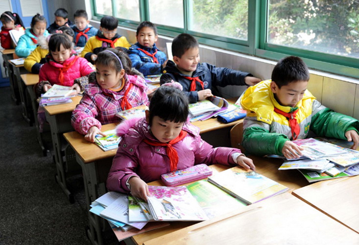 Students get new books in a primary school in Nanjing, Jiangsu province on Thursday, the first day of the new semester for around 800,000 students in the city's kindergartens, primary and secondary schools. The starting day, scheduled for Tuesday, was postponed due to a sudden snowfall that blanketed the province late on Monday night. (Photo/Xinhua)