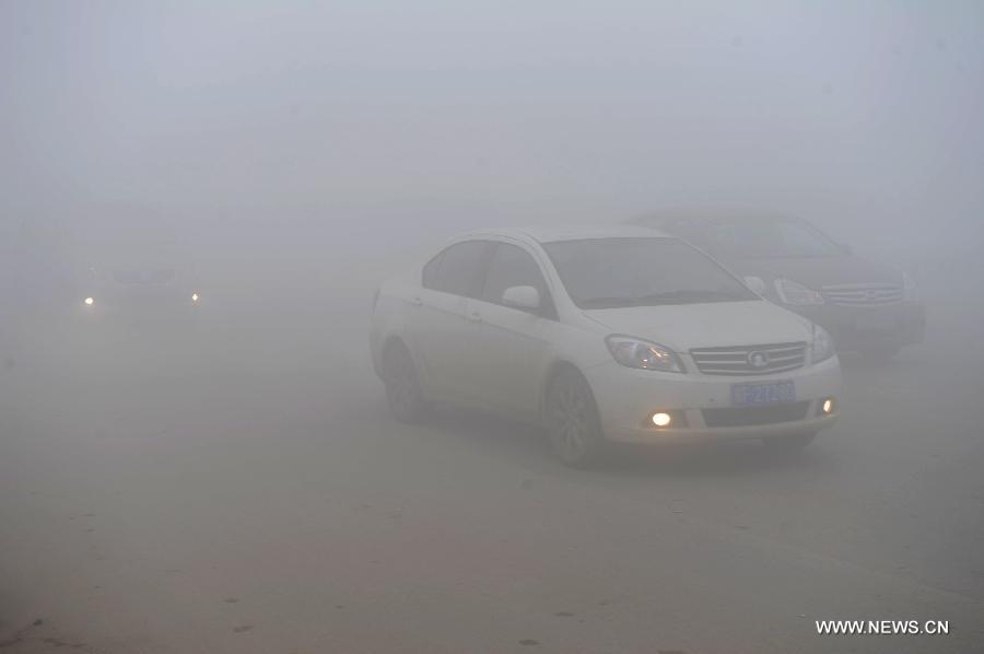 Motorcars run amid heavy fog in Pingxian County, north China's Hebei Province, Feb. 22, 2013. Some parts of Hebei Province were hit by fog and smog on Feb. 22 morning and the provincial meteorological bureau has issued a red alert. (Xinhua/Wang Xiao)  