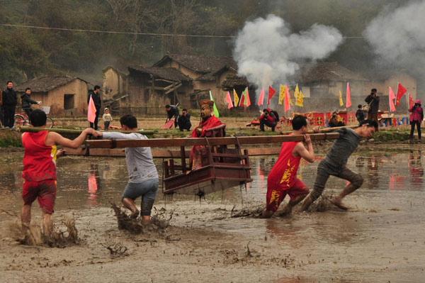 Villagers carrying the statue of Guan Gong (Lord Guan) run in a field during an activity to welcome Lantern Festival which falls on Feb 24, in Julin village, Changting county of East China’s Fujian province on Feb 21, 2013. (Xinhua) 