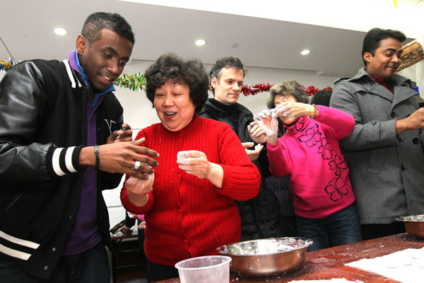 A man from Madagascar learns how to make a ball with rice glue during a Shanghai community activity three days ahead of Lantern Festival which is on Feb 24 this year. (Xinhua)