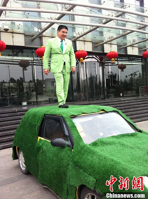Chen Guangbiao stands on the top of a small displacement vehicle and calls people to drive small displacement cars to support environmental protection. (Chinanews/Huang Li)