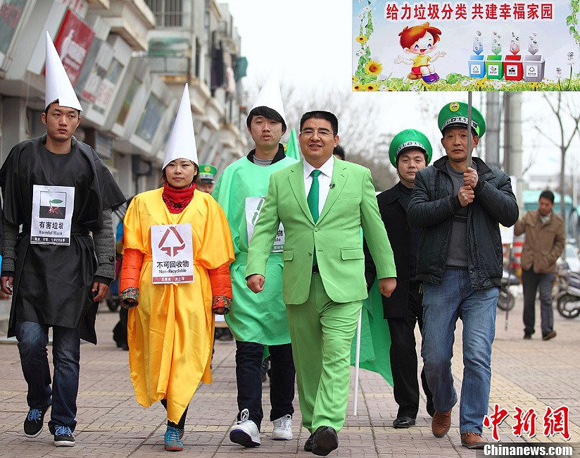 Chen Guangbiao (fourth from left) promotes environmental protection on the street. 11 people who called themselves the entrepreneurs of polluting companies gathered in front of a renewable resources company owned by Chen Guangbiao in Nanjing of Jiangsu. They put on a green cap which represents “green travel” and held some propaganda slogans in response to the call on environmental protection launched by Chen. (Chinanews/Yang Bo)