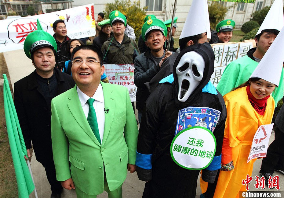 Chen Guangbiao (left front) enters a residential area to promote environment protection. (Chinanews/Yang Bo)