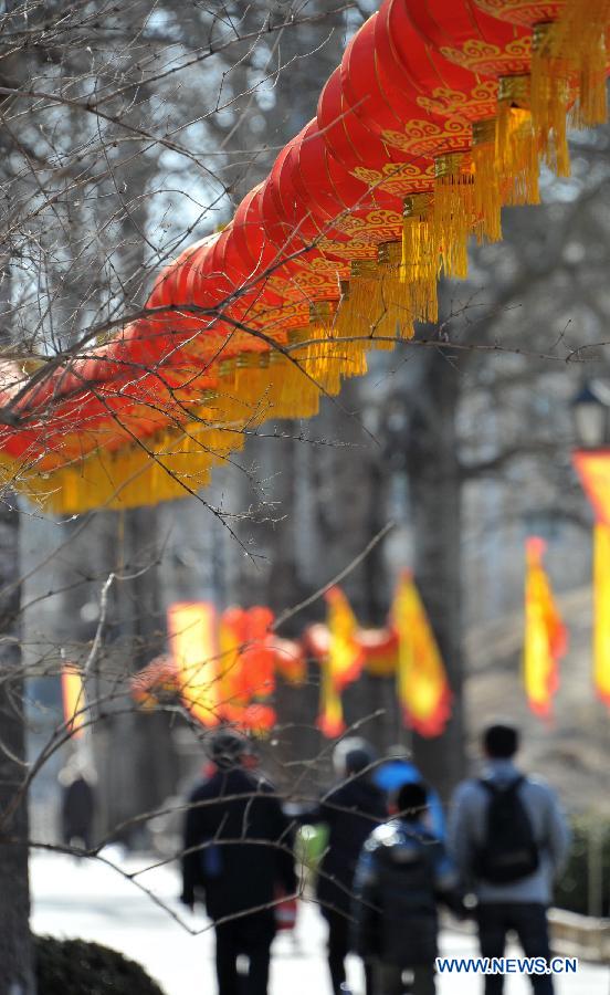 Visitors walk past the red lanterns at the Old Summer Palace, or Yuanmingyuan, in Beijing, capital of China, Feb. 22, 2013. Thousands of red lanterns are hung at the imperial garden to greet the upcoming Lantern Festival, which falls on Feb. 24 this year. (Xinhua/Li Xin)