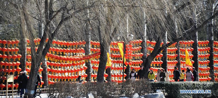 Visitors walk past the red lanterns at the Old Summer Palace, or Yuanmingyuan, in Beijing, capital of China, Feb. 22, 2013. Thousands of red lanterns are hung at the imperial garden to greet the upcoming Lantern Festival, which falls on Feb. 24 this year. (Xinhua/Li Xin)