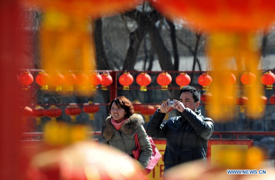 Visitors take photos at the Old Summer Palace, or Yuanmingyuan, in Beijing, capital of China, Feb. 22, 2013. Thousands of red lanterns are hung at the imperial garden to greet the upcoming Lantern Festival, which falls on Feb. 24 this year. (Xinhua/Li Xin) 